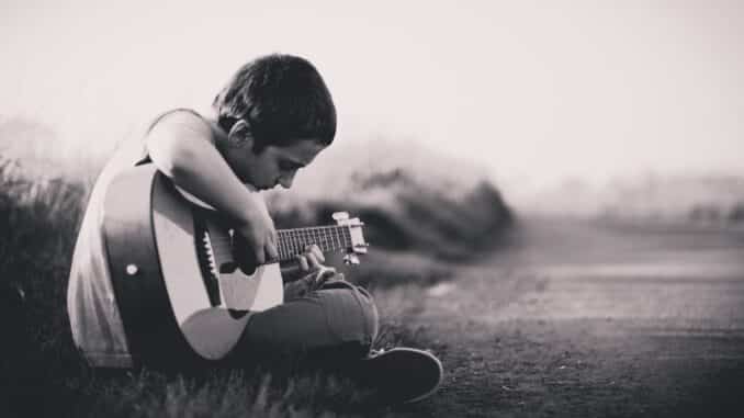 child learning how to play guitar